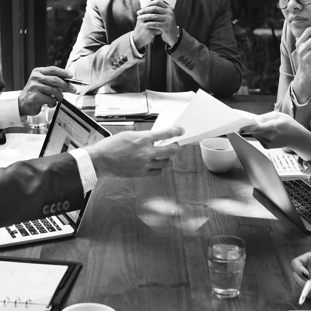 Photo of people at a conference table exchanging information