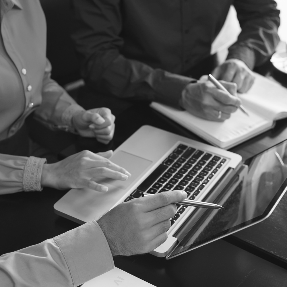 Photo of people working together with a laptop