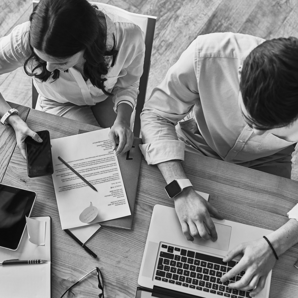 Photo of people working together with a smartphone and laptop